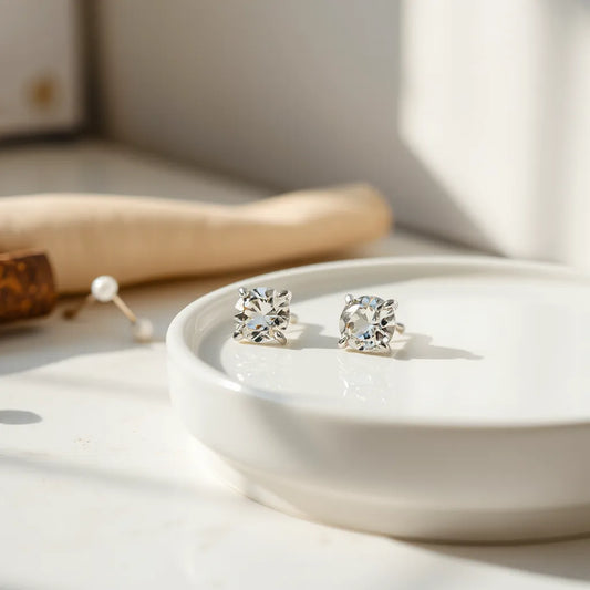 Pair of moissanite earrings on a white tray under soft natural light